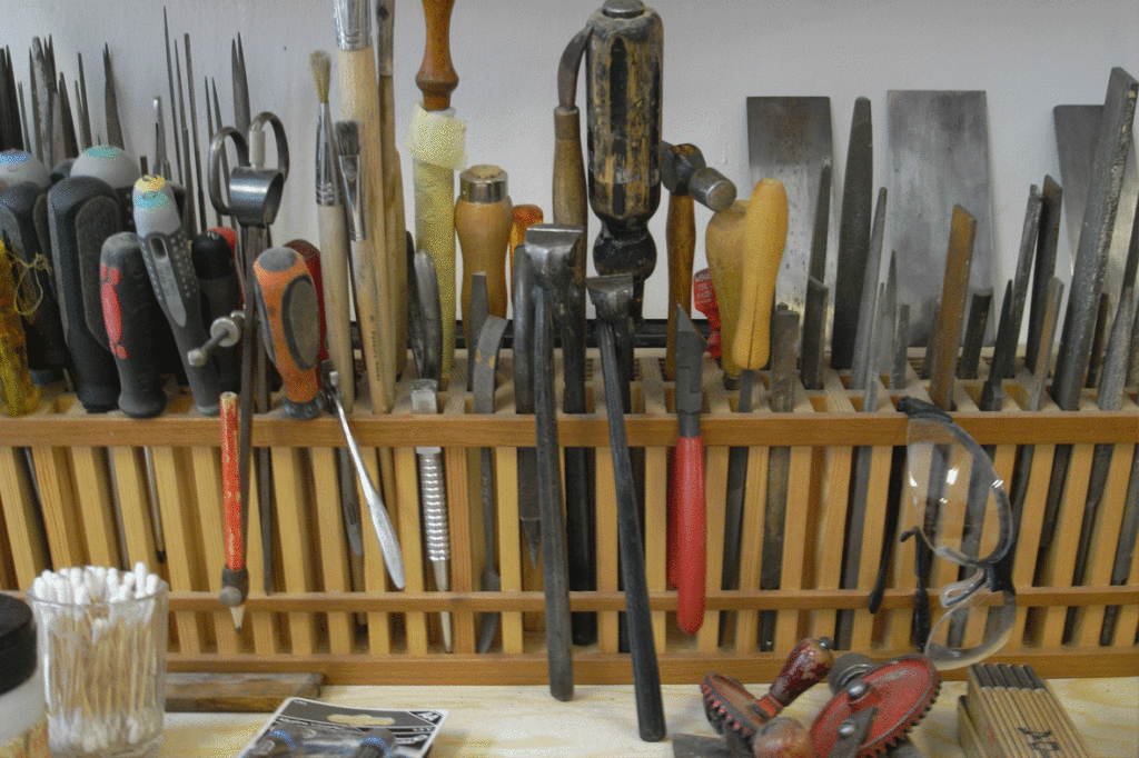 Forskellige redskaber og værktøjer opbevaret i kasse med gitter